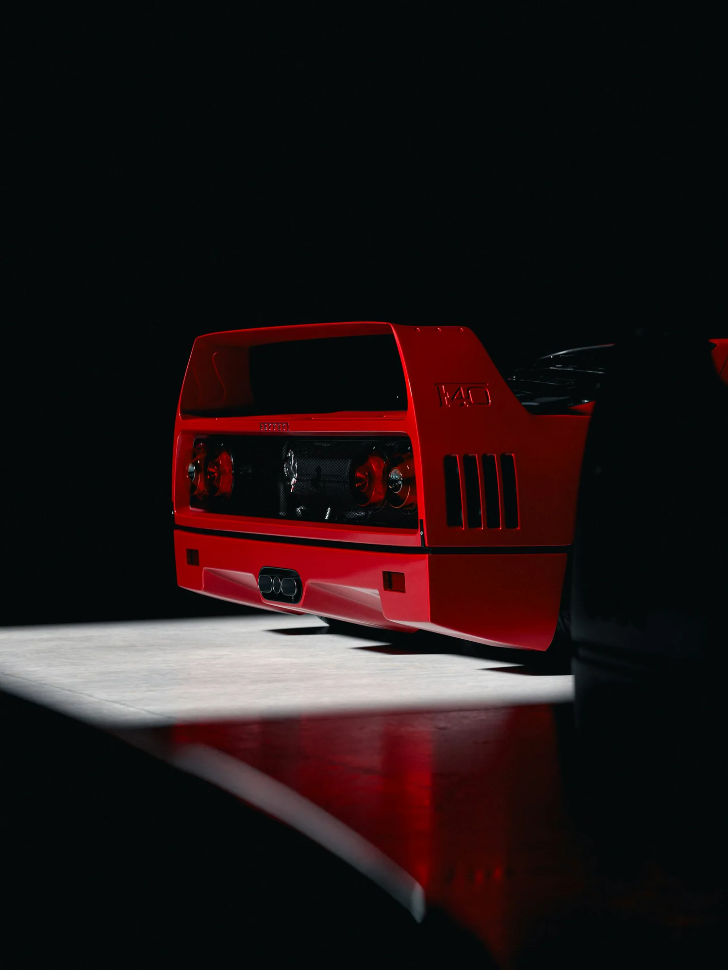 Rear of a red Ferrari F40 in a dark garage